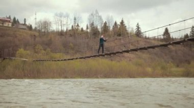 Köprüde kemancı, sokak sanatçısı, dışarıda keman çalıyor. hızlı nehir