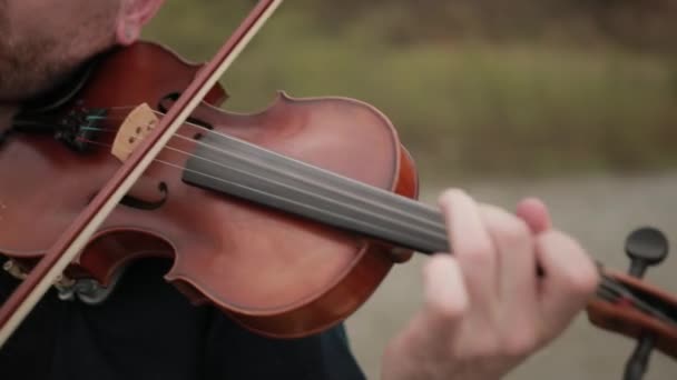 Violinista sul ponte, interprete di strada che suona il violino, fuori. Primo piano — Video Stock