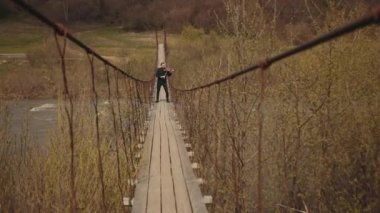 Köprüde kemancı, sokak sanatçısı, dışarıda keman çalıyor. hızlı nehir