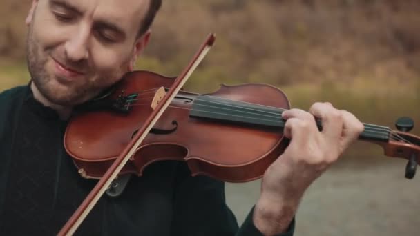 橋の上にヴァイオリニスト、通りの演奏者は、外でバイオリンを演奏。閉鎖 — ストック動画
