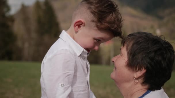 Relaciones entre generaciones. nieto toca la frente a las abuelas cabeza — Vídeo de stock