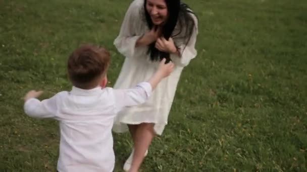 Весело бегает, малыш играет в парке с мамой, мать играет своего сына — стоковое видео