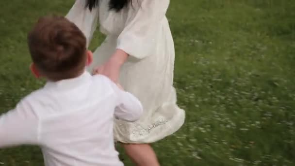 Divirta-se correndo, menino brincando no parque com a mãe, mãe joga seu filho — Vídeo de Stock