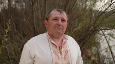 Yaşlı büyükbaba yaşlı yaşlı bir adam nehir kıyısında nakış işliyor.