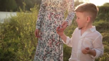Anne ve oğlu nehirde, taş atıyorlar, genç bir aile yürüyüşe çıkmış. Öğretim