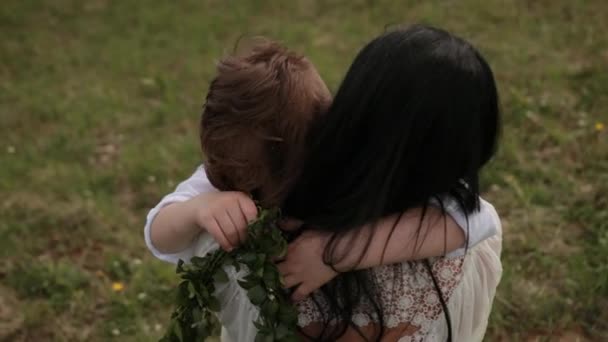 Primer plano amoroso joven madre abrazando, calmando pequeño hijo que está llorando al aire libre — Vídeos de Stock