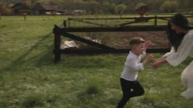 Koşarken eğlenen, annesiyle parkta oynayan küçük çocuk, annesi oğlunu oynuyor.