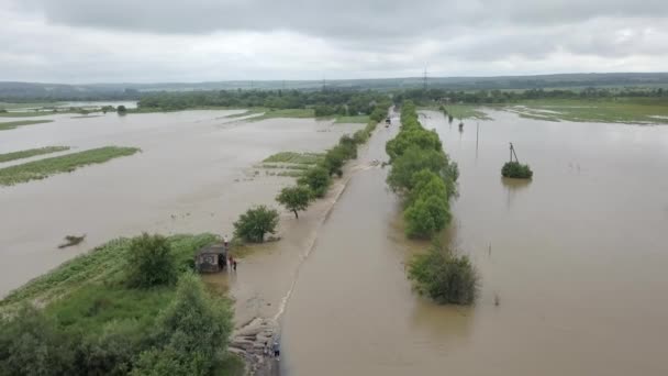 Flooded road heavy rain flooding taken during drone flight overflowing river — Stock Video