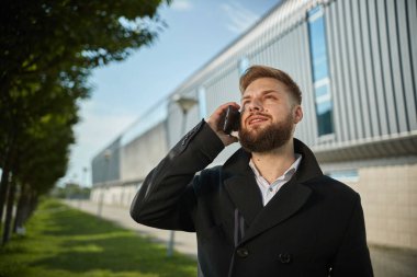Şehir işadamı akıllı telefonlardan bahsediyor. Havaalanından dışarı çıkıyor.
