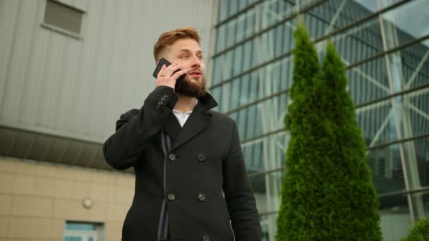 Glücklicher, aufgeregter junger Geschäftsmann, der mit dem Handy telefoniert. Attraktives Geschäft — Stockvideo