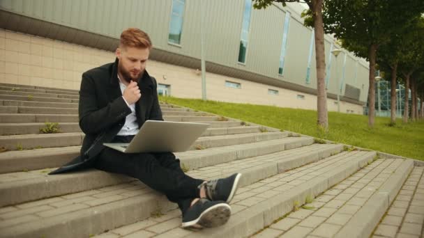 Hezký elegantní muž pracující venku, zaostřený laptop, užívající si, vousatý hipster — Stock video
