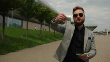 Havalı zengin adam parayı çöpe atıyor. Müdür 100 dolarlık banknotları dışarı atıyor.