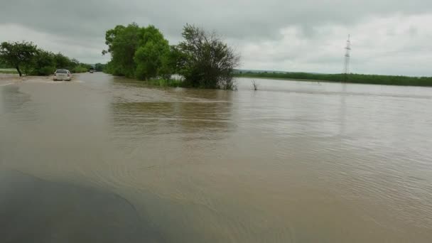 Coches que conducen por carretera inundada durante una inundación causada por fuertes lluvias, agua de lluvia — Vídeo de stock
