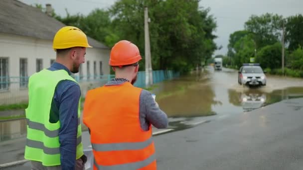 Mužští inženýři řeší povodňové problémy. Devastace způsobená masivními katastrofami — Stock video