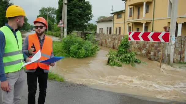 Ingegneri maschi risolvere il problema alluvione. Devastazione causata da gravi catastrofi — Video Stock