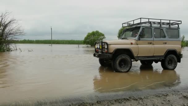 Auta jedoucí po zatopené silnici během povodně způsobené silným deštěm, dešťovou vodou — Stock video