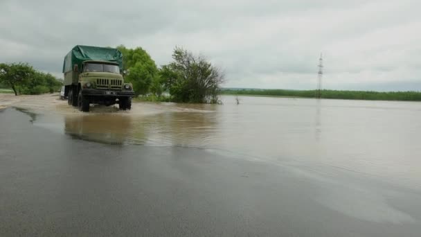 Автомобілі, що їздять по затопленій дорозі під час повені, викликаної сильним дощем, дощовою водою — стокове відео