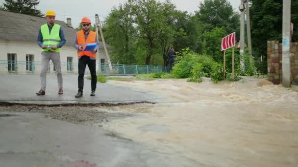 Mannelijke ingenieurs lossen overstromingen op. Verwoesting na massale rampen — Stockvideo