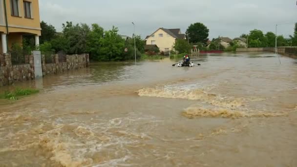 Banjir korban yang duduk di perahu karet diselamatkan oleh sepasang penyelamat. Keluarga — Stok Video