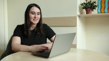 Kadın çalışan, çeşitli meslektaşlarıyla çevrimiçi brifingde konuşma videosu görüşmesi yapıyor.