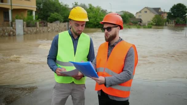 Két férfi mérnök megoldja az árvíz problémáját. Természeti katasztrófa jelentős árvíz — Stock videók