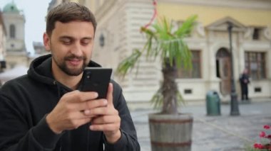 Video görüşmesi yapan adamın portresi. Mutlu erkek dışarıda sohbet ediyor. Heyecanlı adam