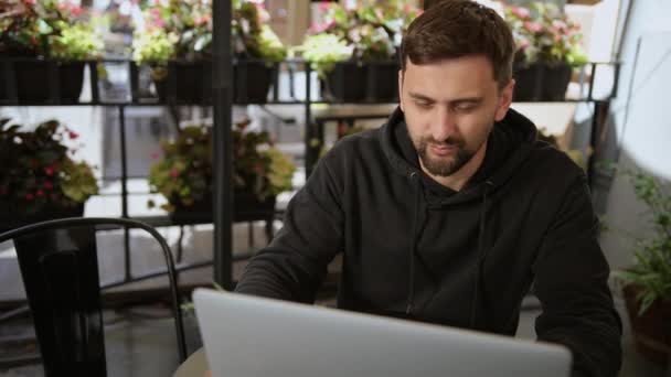 Beszélgetünk. A fiatal üzletember távolról dolgozik. férfi számítógéppel az utcán. — Stock videók