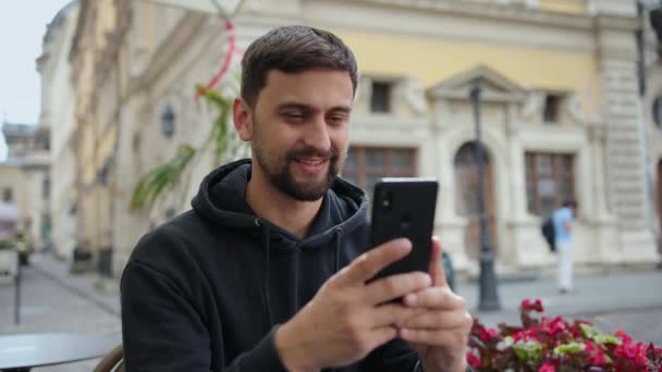 Hipster facet z telefonu komórkowego aparat cyfrowy rozmowy podczas siedzenia w kawiarni — Wideo stockowe