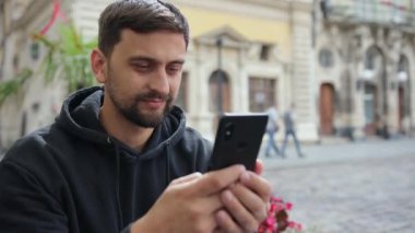 Portre işçisi dışarıdaki video görüşmelerinde akıllı telefonla mesaj okuyor.