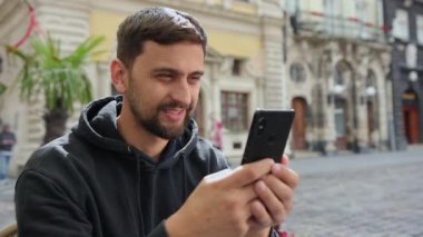 Portre işçisi dışarıdaki video görüşmelerinde akıllı telefonla mesaj okuyor.