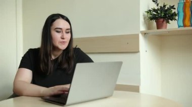 Kadın çalışan, çeşitli meslektaşlarıyla çevrimiçi brifingde konuşma videosu görüşmesi yapıyor.