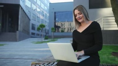 Sokakta dizüstü bilgisayarda çalışan özenli bir kadın. İş kadını.