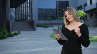 Şehirde tablet kullanan güzel bir genç kadın. İş kadınına yakın çekim.