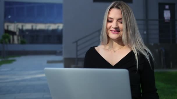 Молодая деловая женщина с ноутбуком на улице. business woman sitting. — стоковое видео