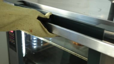 Fırından fırında pişmiş turta çıkaran kişi. Fırında erkek fırıncı, adam turta pişiriyor.
