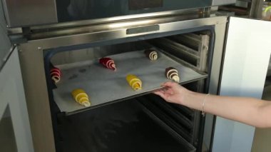 Fırın tepsisinden çiğ hamur çıkarıyor. Pastanede kruvasan pişirme, kontrol