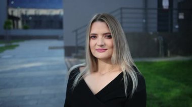 Yarı hoşsohbet biriyle konuşan güzel bir iş kadınının portresi.