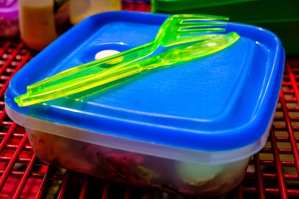 Plastic knife and fork on top of lunch box ready for picnic