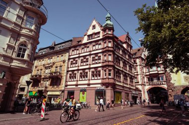 Bir Freiburg im Breisgau, Baden Wurttemberg, Almanya - 30 Temmuz 2018: Martin's Gate (popüler) yakınındaki kavşak bisikletçiler ve insanlarla geziniyor. Kara Orman Almanya'nın güneybatı bölgesi