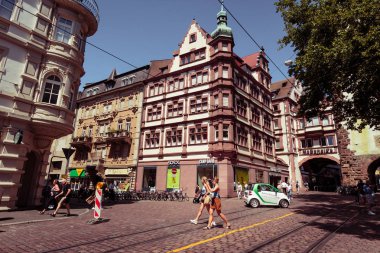 Bir Freiburg im Breisgau, Baden Wurttemberg, Almanya - 30 Temmuz 2018: Martin's Gate (popüler) yakınındaki kavşak kişi geziniyor ve küçük elektrikli otomobil ile. Kara Orman Almanya'nın güneybatı bölgesi