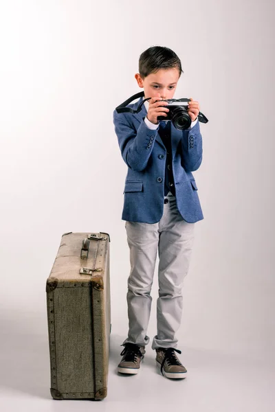 Giovane ragazzo vestito con macchina fotografica e valigia — Foto Stock