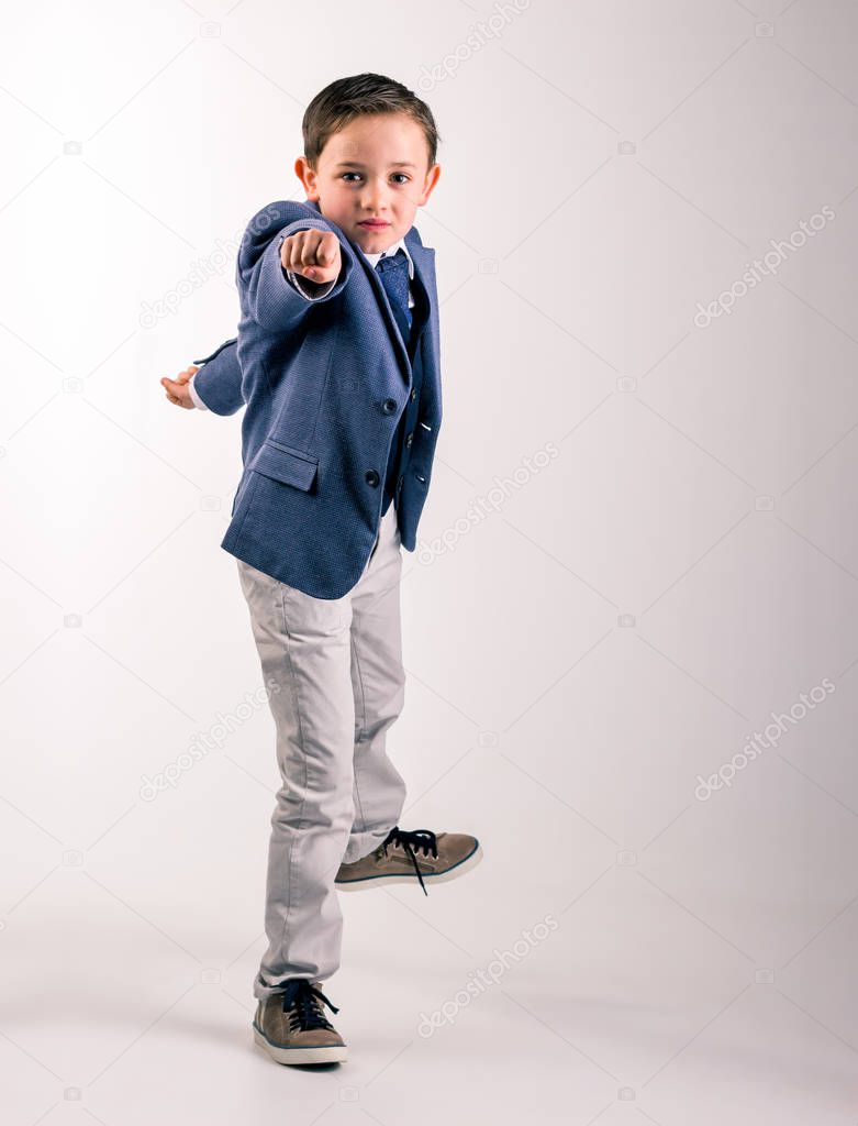 Boy in suit pointing fist forward