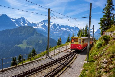 Schynige Platte, Bernese Oberland, İsviçre - 11919 Ağustos: Arkaplanda Eiger, Monch ve Jungfrau dağları ile Schynige Platte istasyonu yakınlarındaki turist treni