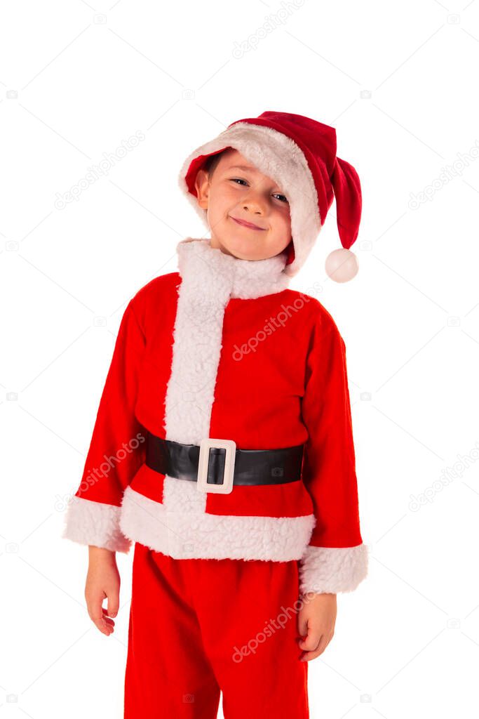 Portrait of a cute little boy (4 years old) standing up smiling wearing a red Santa Claus costume with a Santa hat. Christmas and holidays theme isolated on white