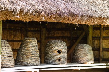 Rafta eski, boş, geleneksel, dokunmuş arı kovanları.