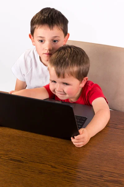 4歳の幼児はラップトップコンピュータで楽しんでいますが 兄は肩に気をつけています 白い背景に隔離された高い角度の眺め — ストック写真
