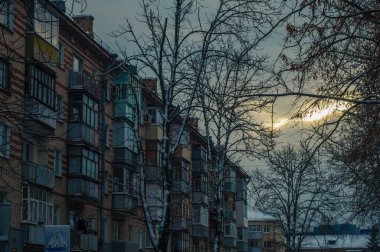 Güneş, gökyüzünü bir apartmanın arka planına doğru kesiyor.
