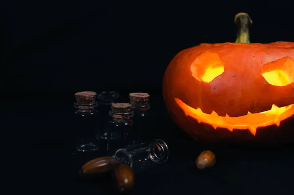 Halloween pumpkin next to empty magic cones on black background — Stock Photo, Image