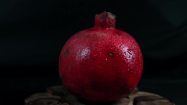 Granaatappel fruit op een zwarte achtergrond draait rond zichzelf — Stockvideo