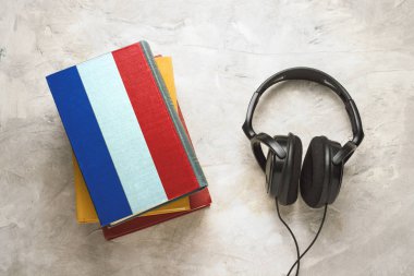 Kulaklık ve bir yığın kitap. Üst kitap Fransa bayrağı şeklinde bir kapak vardır. Kavram ekran talimatlarını izleyin. Dil öğrenmek. Fransızca dil.